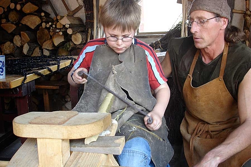 Ein Junge übt sich im Holzschnitzen auf der Ehrenburg